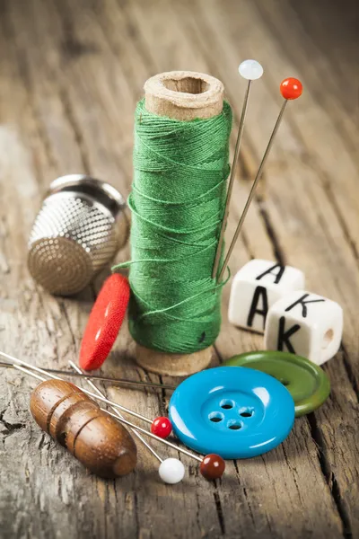 Single green spool of sewing thread and scattered buttons and needles Stock  Photo by ©graphia76 42037125